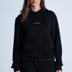 Kobieta w czarnej bluzie z kapturem – logo DEQS i komfortowy krój