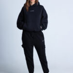 Kobieta w czarnej bluzie DEQS – look casual z krótkimi spodenkami