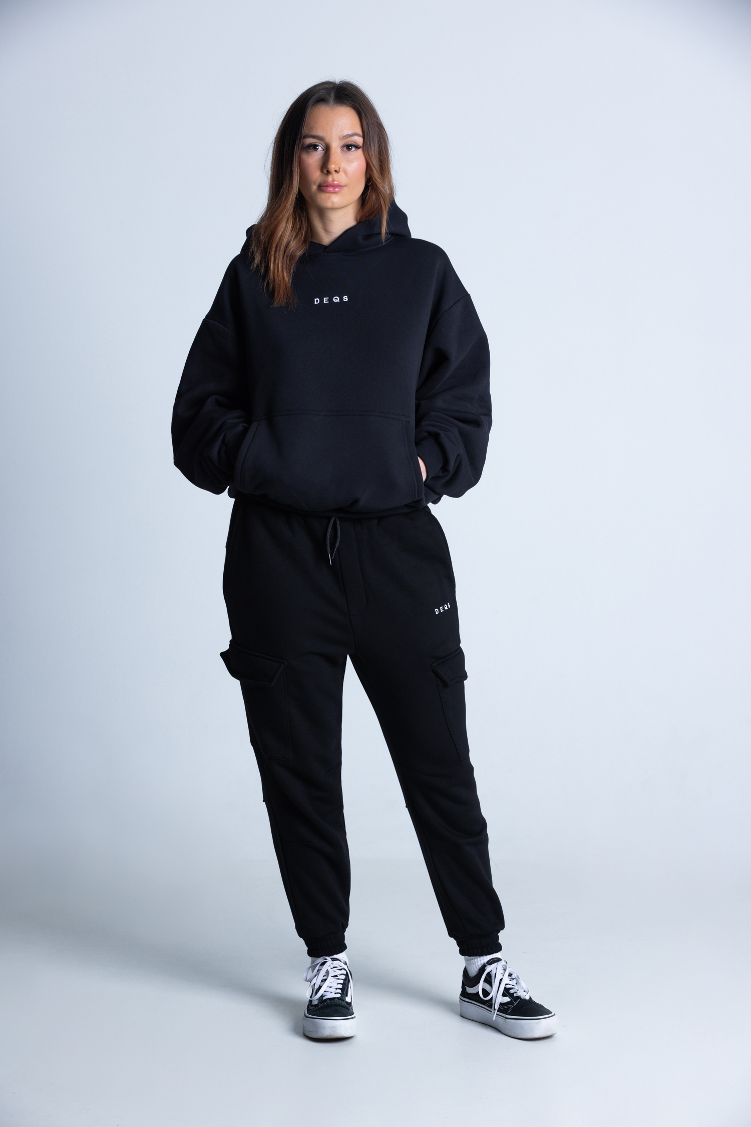 Kobieta w czarnej bluzie DEQS – look casual z krótkimi spodenkami