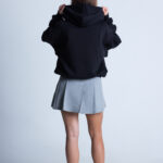 Kobieta poprawiająca kaptur bluzy DEQS – casual streetwear z eko przekazem