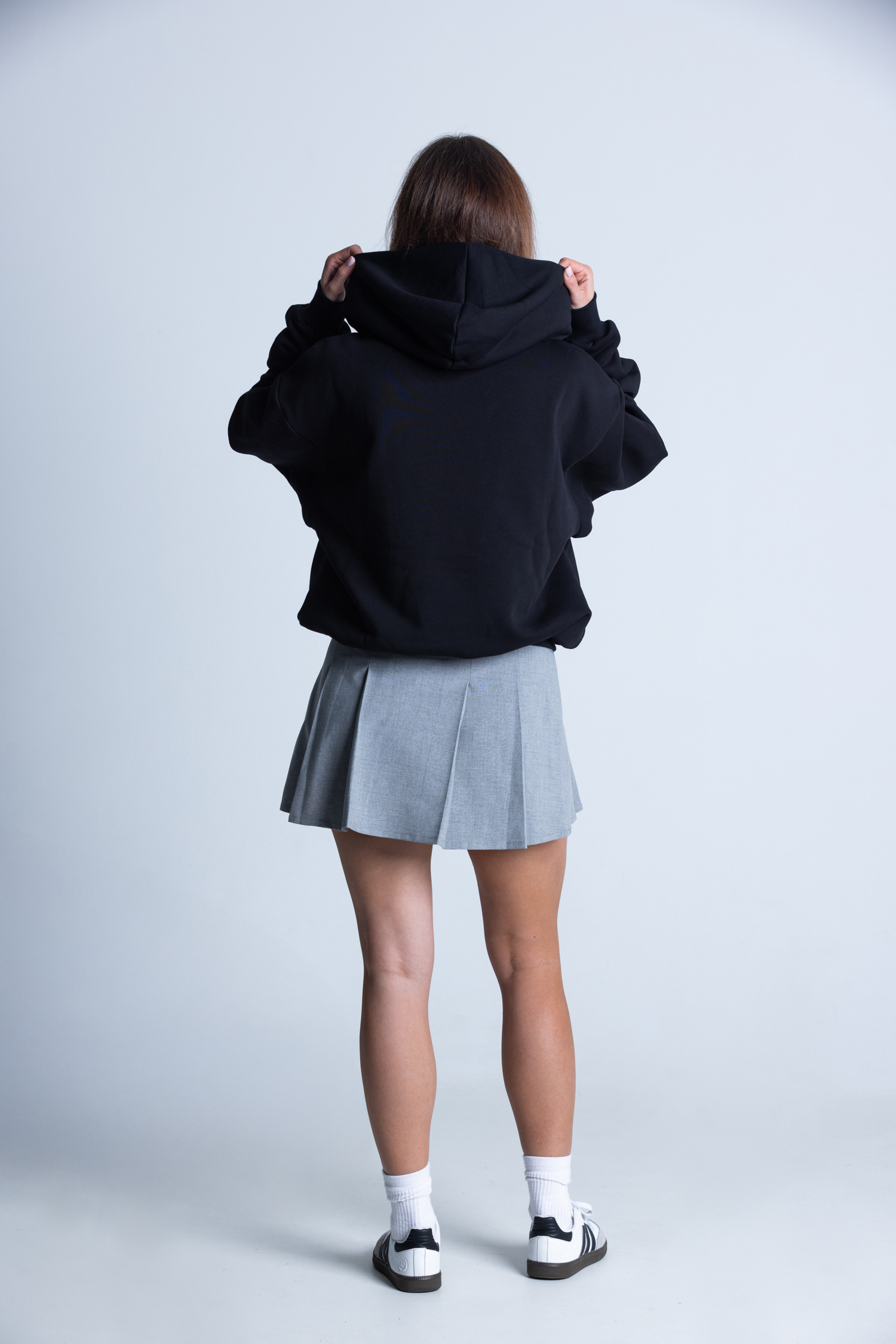Kobieta poprawiająca kaptur bluzy DEQS – casual streetwear z eko przekazem