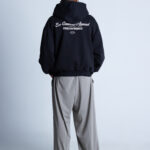 Mężczyzna w czarnej bluzie DEQS – tył z nadrukiem „Eco Conscious Apparel”