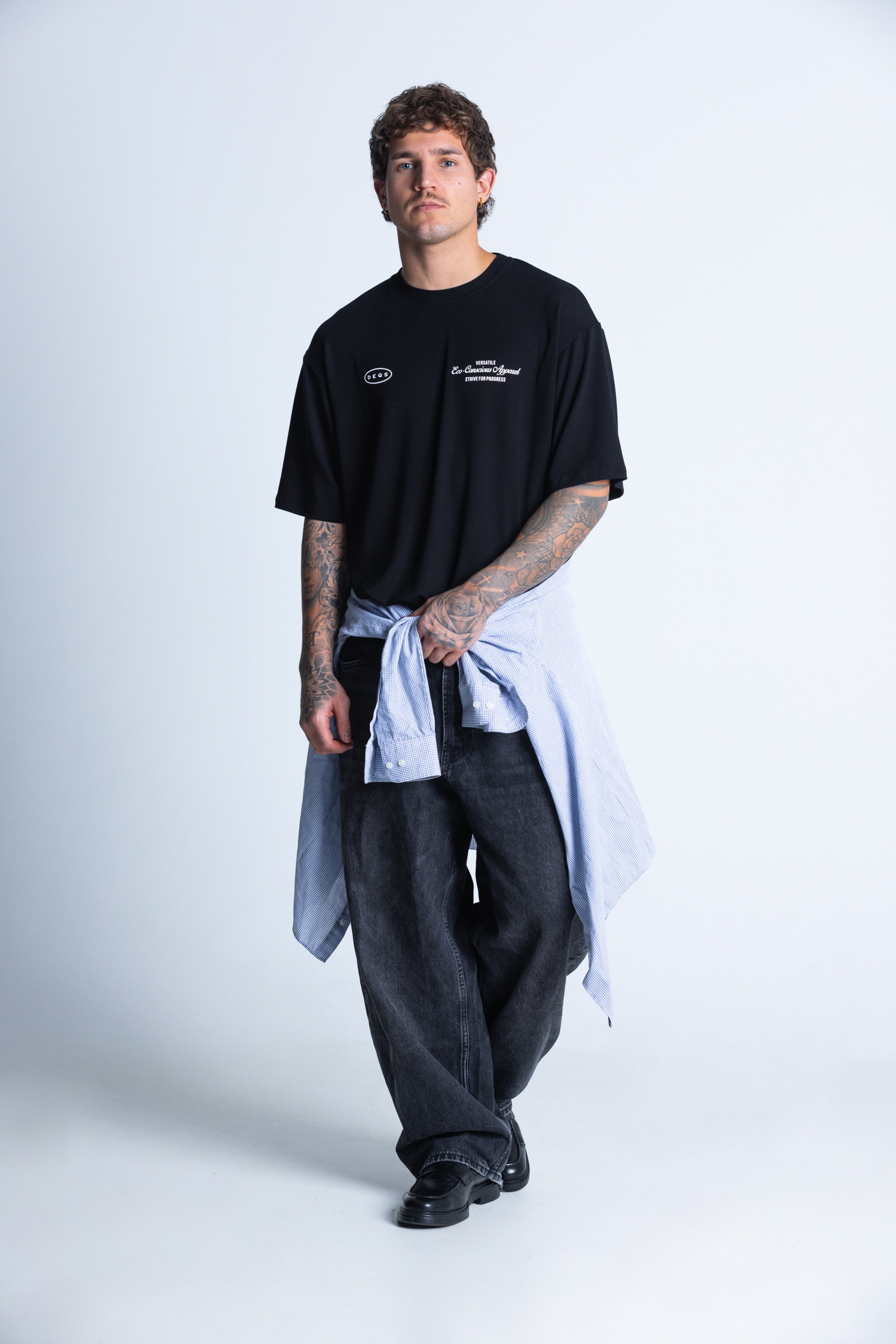 Model w T-shircie DEQS – czarna koszulka z brandingiem