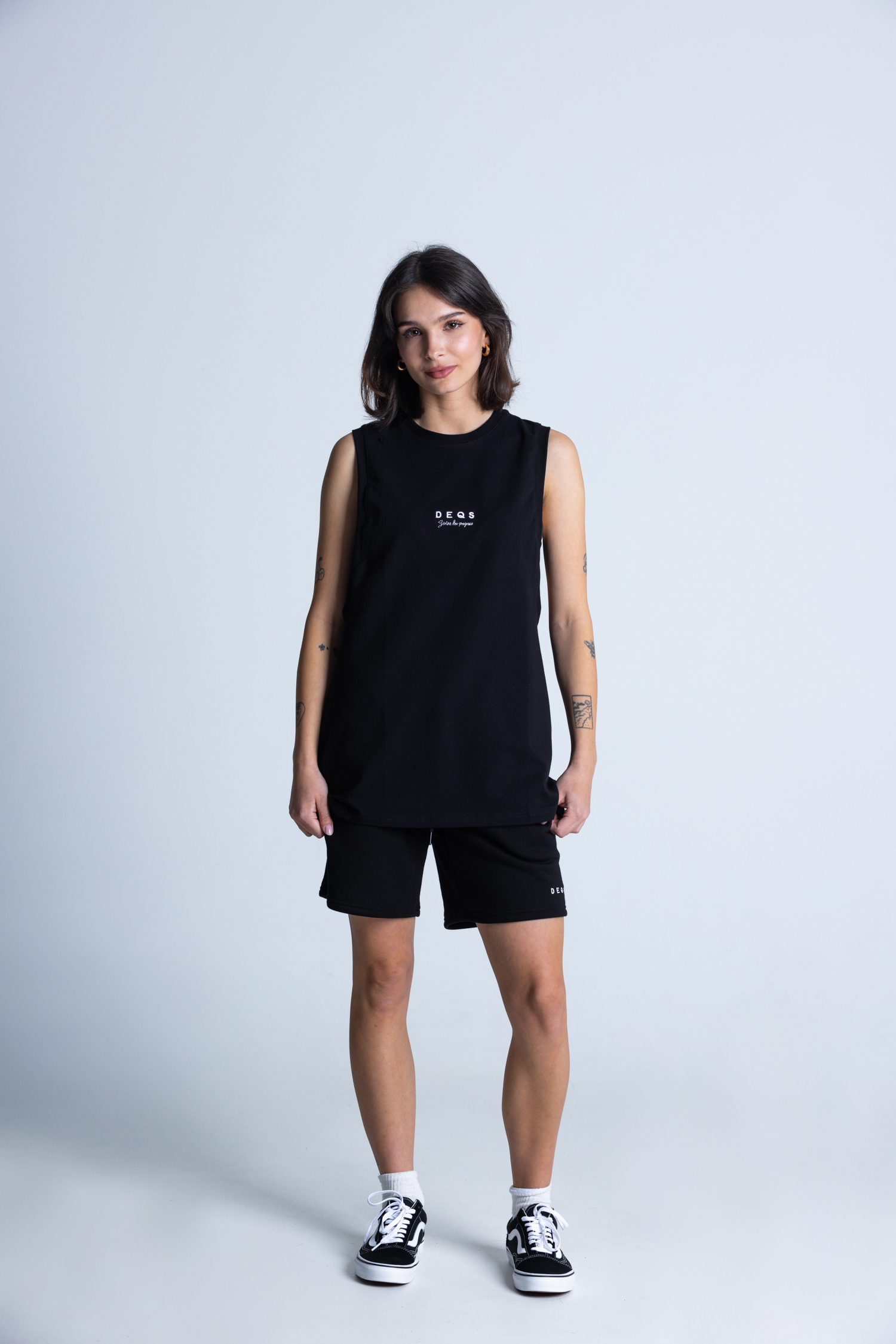 Kobieta w czarnym bezrękawniku DEQS – styl streetwear unisex