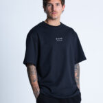 Model w koszulce DEQS – minimalistyczne logo na przodzie, styl casual