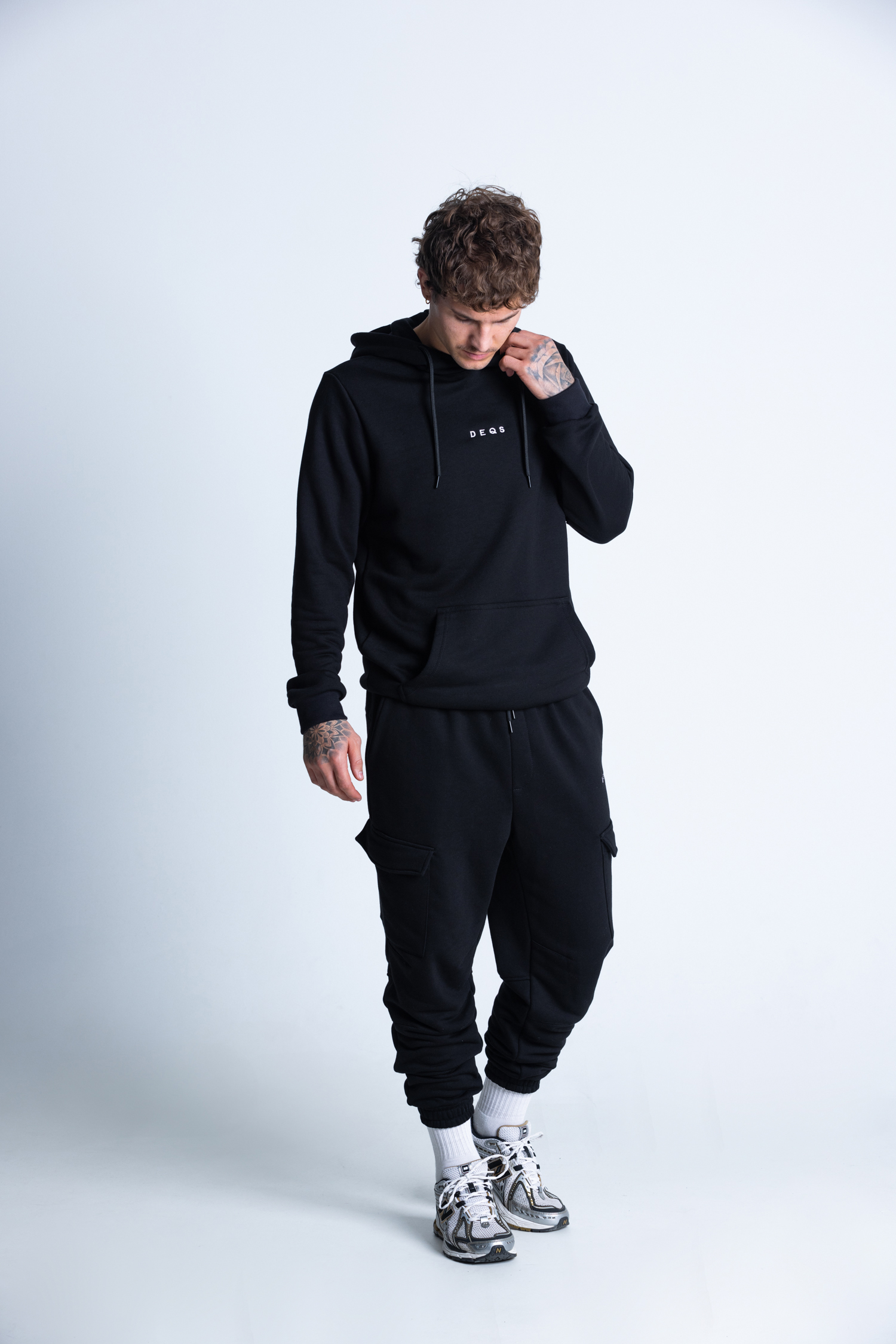 Mężczyzna w czarnej bluzie i spodniach DEQS – komplet streetwear