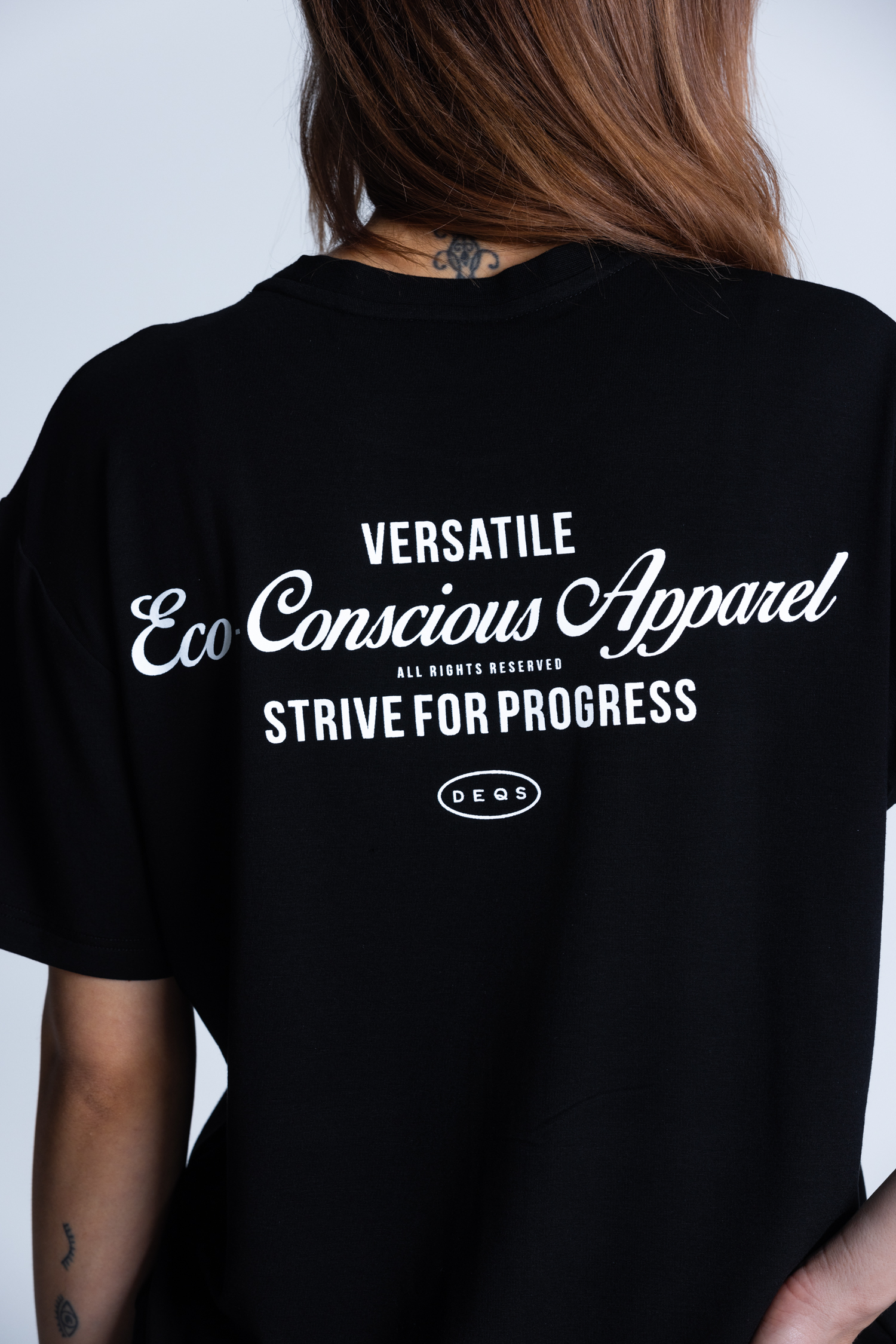 Tył koszulki DEQS – logo + hasło „Strive for Progress” – streetwear eco