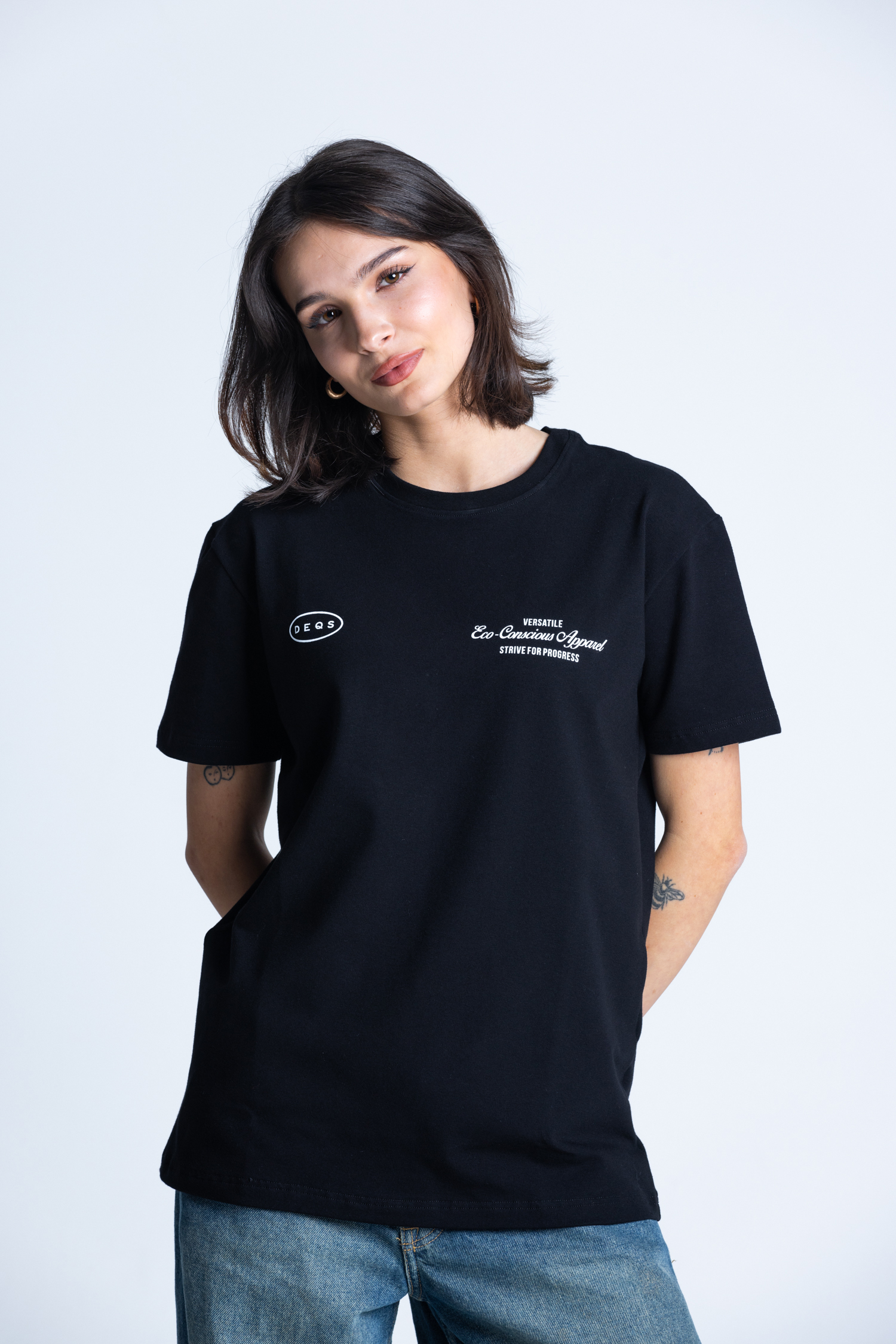 Kobieta w czarnym T-shircie DEQS – logotyp na piersi, look minimalistyczny