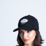 Kobieta w czapce z daszkiem DEQS – logo marki, styl casual streetwear