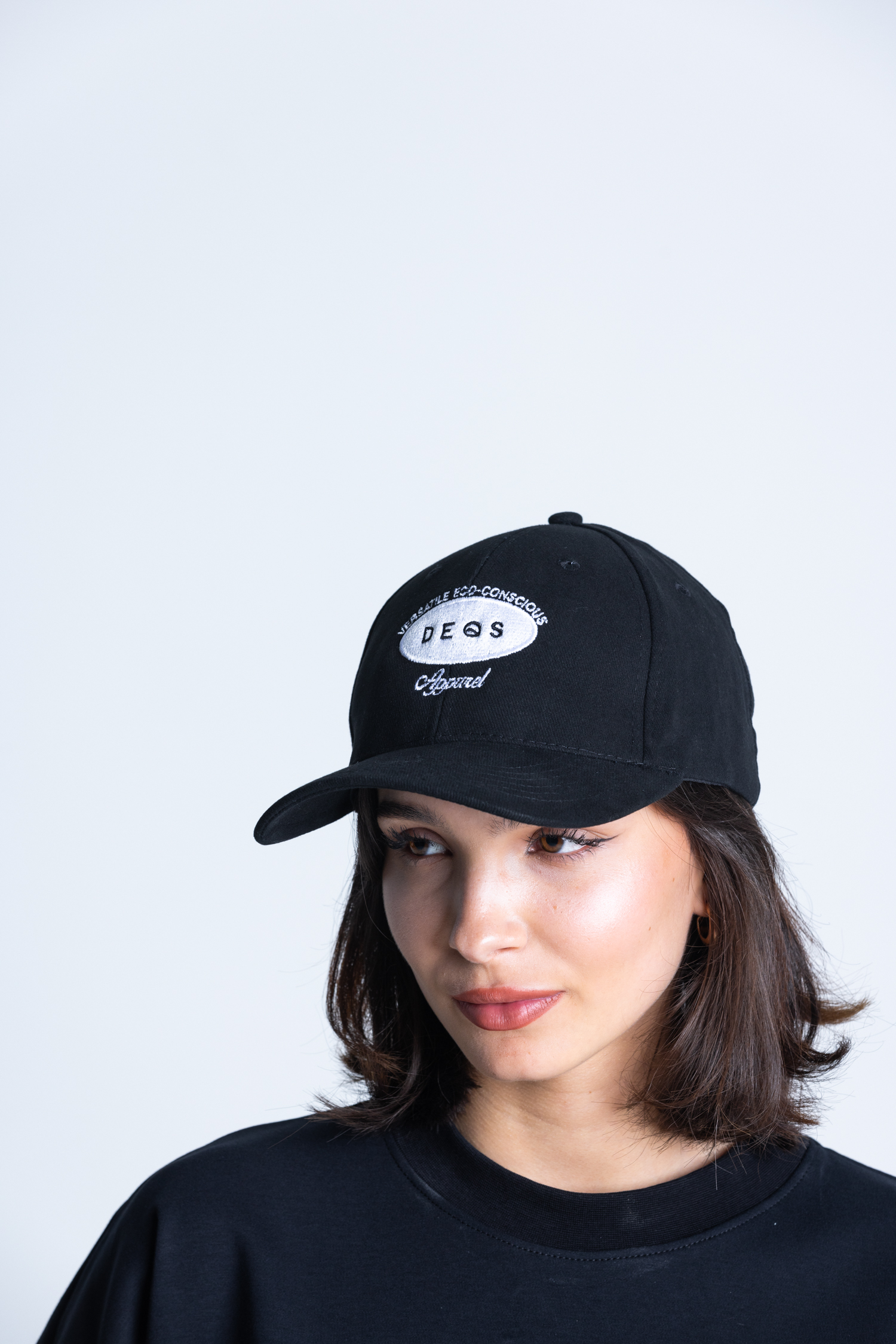 Kobieta w czapce z daszkiem DEQS – logo marki, styl casual streetwear
