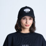 Kobieta w czapce i koszulce DEQS – zestaw streetwear z logotypem