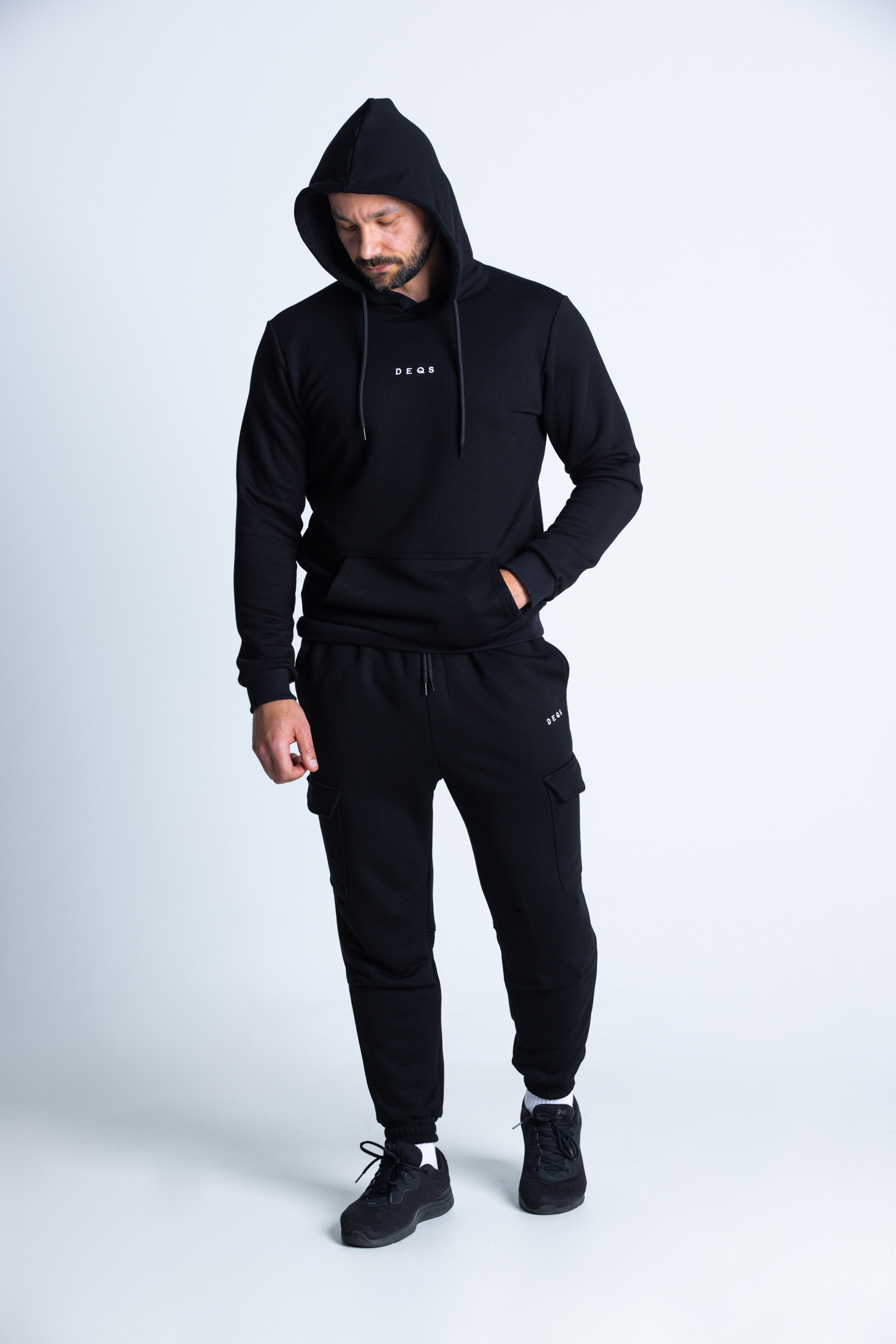 Mężczyzna w czarnym zestawie DEQS – look gymwear lifestyle