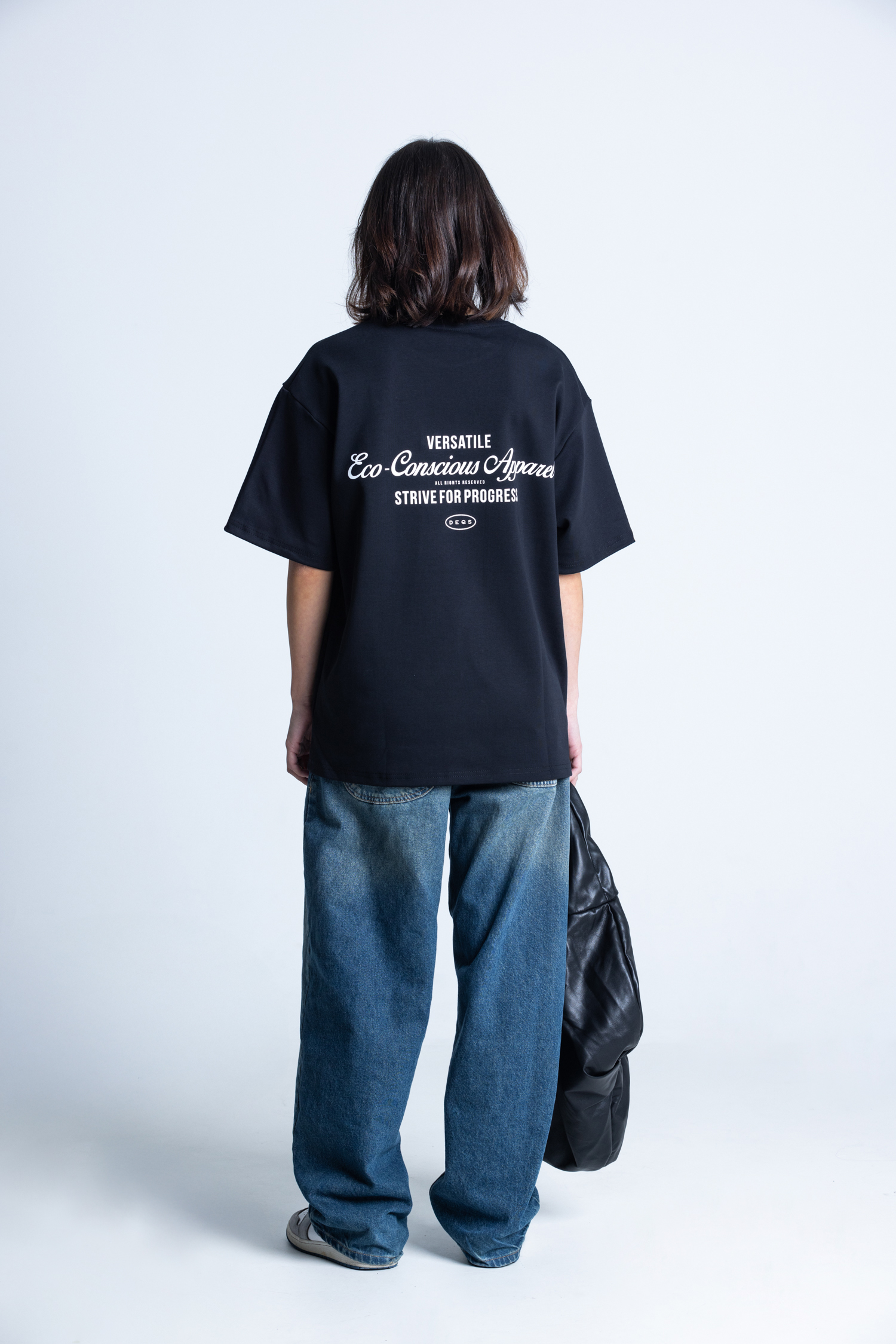 Modelka tyłem w czarnej koszulce DEQS – ekologiczna odzież oversize