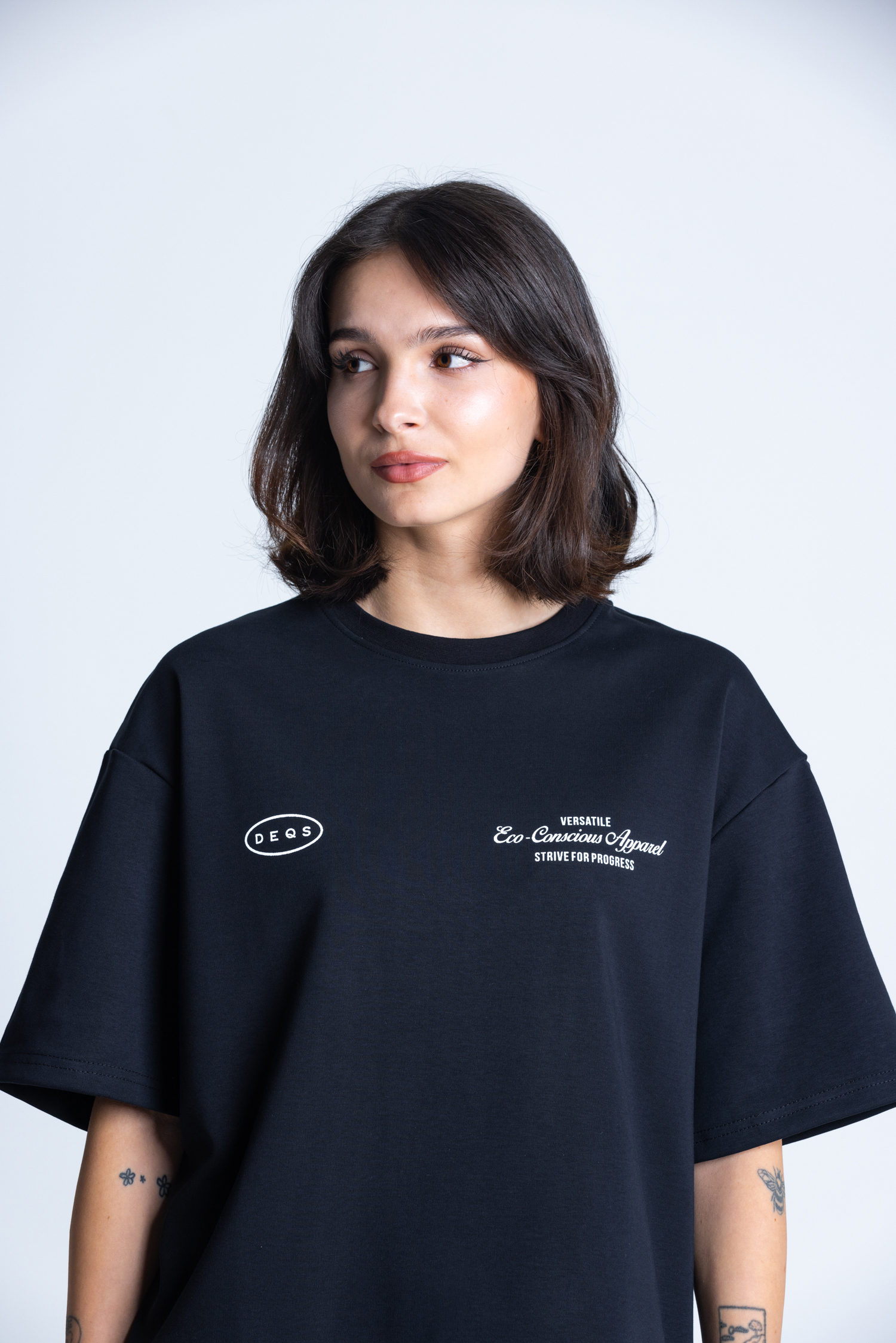 Modelka w T-shircie DEQS z logo i symbolem eko – minimalistyczna odzież damska